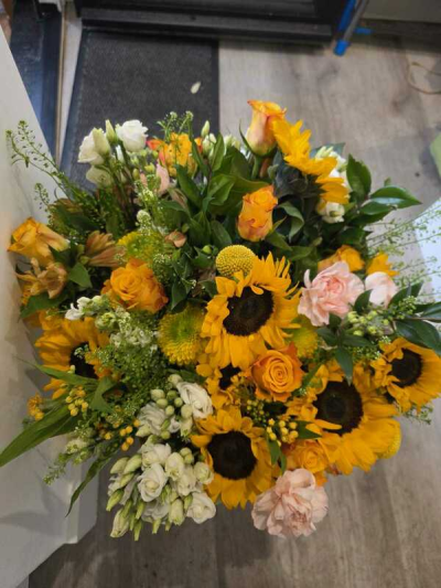 Sunset Blush - Handcrafted by The Florist of Bere, this stunning bouquet features vibrant sunflowers with fresh foliage in a bright and uplifting design.