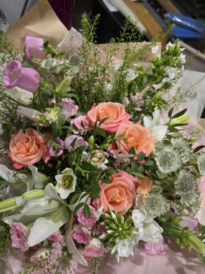 Garden Romance - A lush, romantic arrangement with a soft, garden-gathered feel. Warm peach and blush tones are layered with delicate pinks, creamy whites, and fresh greenery, creating a beautifully textured and airy display. The natural, free-flowing style adds movement