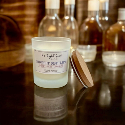Midnight Distillery - Step into the heart of a distillery with our Midnight Distillery candle, lovingly handmade in Denmead. This rich fragrance blends aged whisky, smouldering peat, and a touch of dark chocolate to evoke the warmth of a whisky warehouse, where oak barrels rest in the shadows and smoky aromas linger.

Crafted from vegan-friendly soy wax and infused with paraben and phthalate-free fragrance oils, it is presented in a reusable frosted glass jar with a wooden lid. A candle care card is included to help you enjoy it to the fullest.

Locally made and richly distinctive, this candle is a little piece of smoky indulgence, created in Denmead.